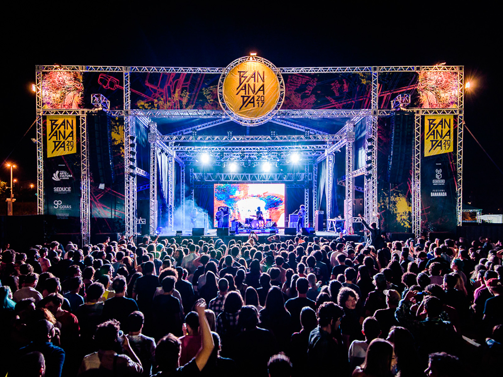 Multidão diante do palco principal do Bananada 2017, com o logo do festival no topo da estrutura